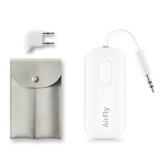 White AirFly wireless earbud transmitter with a 3.5mm jack adapter, a light gray fabric pouch, and a white two-pin travel adapter on a white background.
