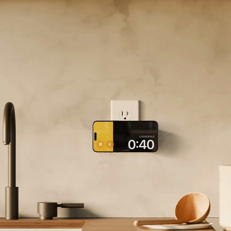 Smart phone with a timer app displayed on a kitchen counter next to a wall outlet.
