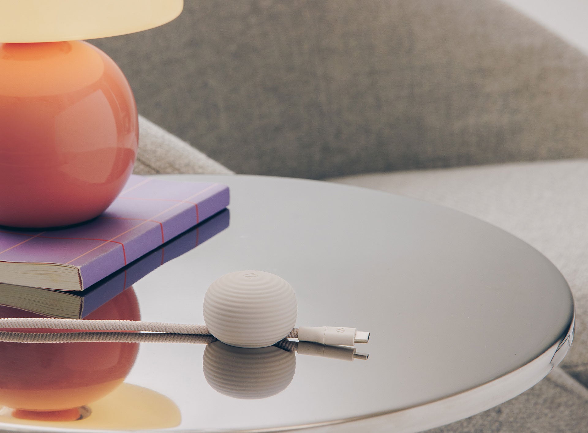 Round table with a lamp, book, and decorative item on a blurred background