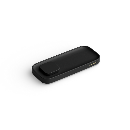 A sleek black rectangular charging valet with rounded corners and a small raised button on top, shown at an angle on a clean white background. The brand name Twelve South is printed in small gold lettering on the right side.