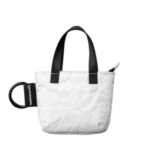 White quilted tote bag with black handles and a visible brand logo on a white background
