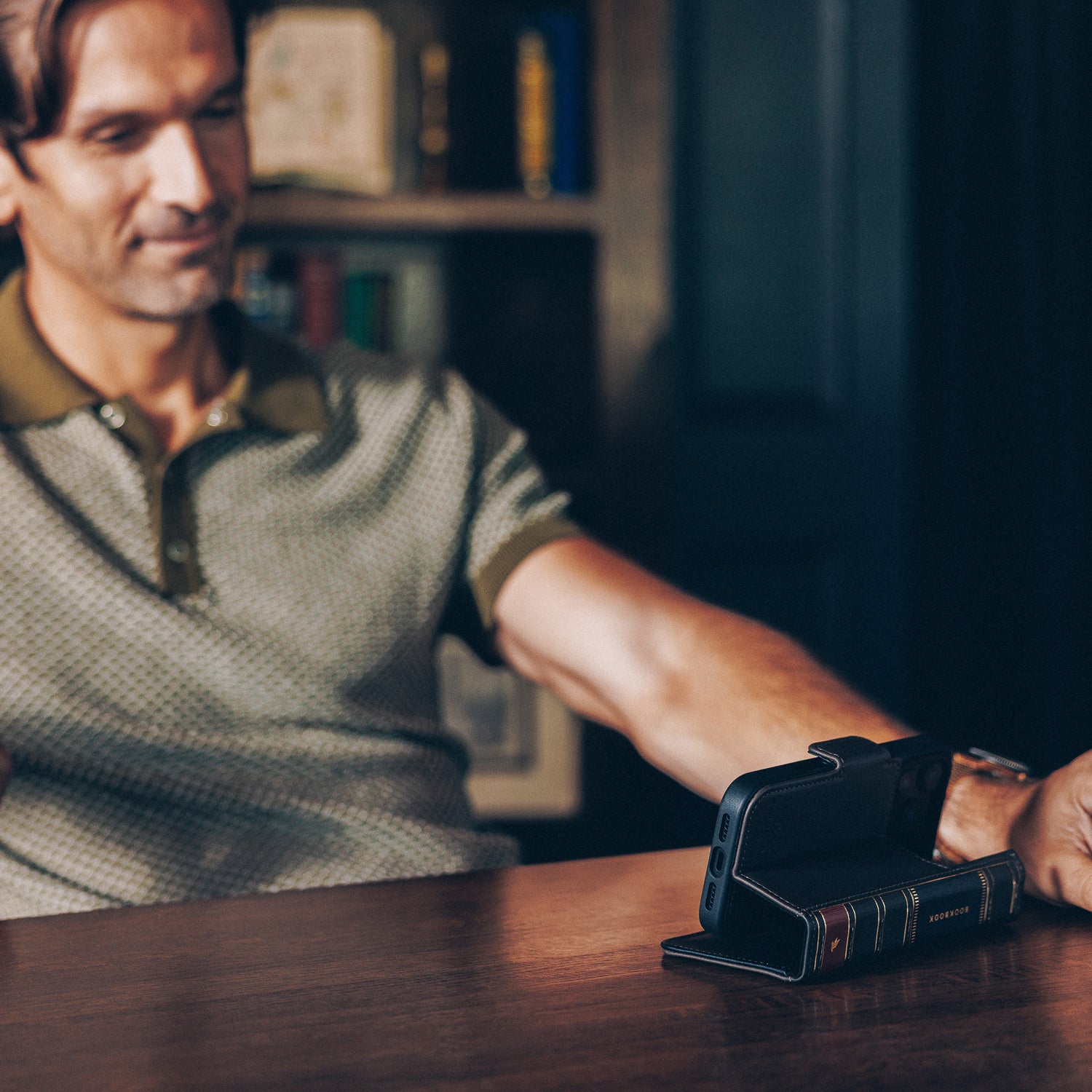 Man sitting at a table with a smartphone on a stand in front of him