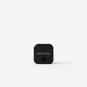 A small black square electronic device with rounded corners and the text 'airfly drive' printed on the front, centered on a light gray background.