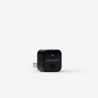 A black Airfly Drive plug-in device with a USB-C connector, featuring a small blue LED indicator light and the 'airfly drive' logo on the front, set against a clean white background.