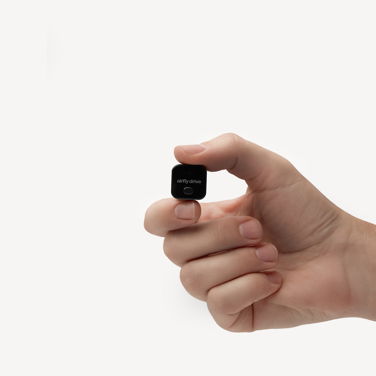 A hand holding a small black square device with the brand name 'nifty drive' printed on it, set against a plain white background.