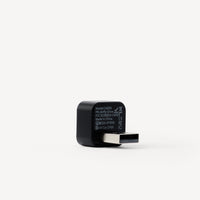 A black USB-C to USB-A adapter with white printed specifications on its side, shown on a clean white background.