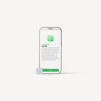 A smartphone centered on a light gray background with a small white CarPlay device in front of it. The phone screen shows the CarPlay welcome interface with green and black text.