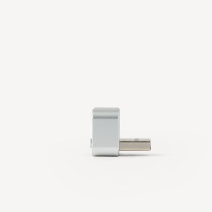 A small silver metal USB-C connector, shown from a side profile view against a clean white background.